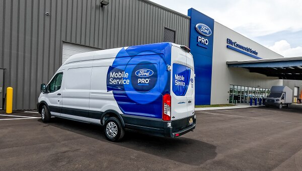 A Ford Pro mobile service van parked in front of an Elite Commercial Service Center.